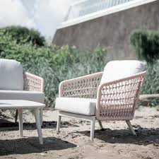 The Poinciana pink collection club chair on a beach.