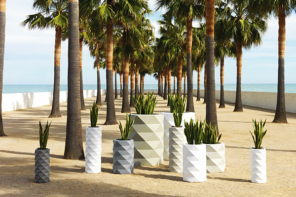 A collection of Marquis planters by Vondom under palm trees.