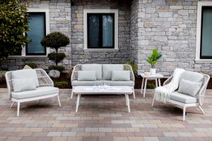 Los Colinas by Ratana conversation set in front of a beautiful house with brick and trees.